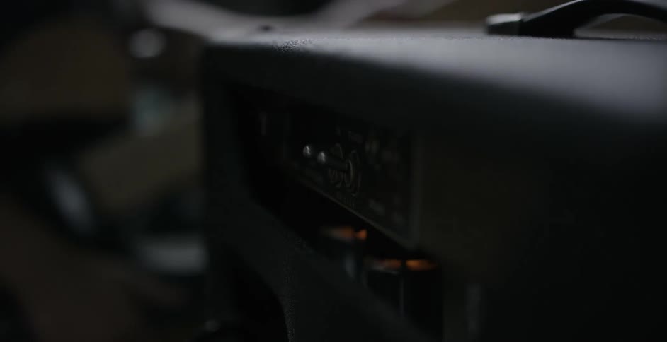 A musician flipping a switch on a piece of equipment