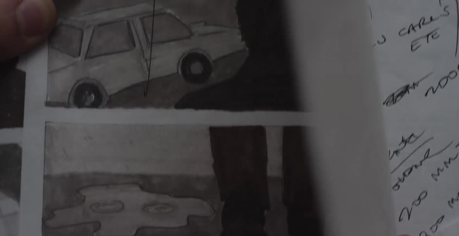 A person is examining paper with illustrations on it