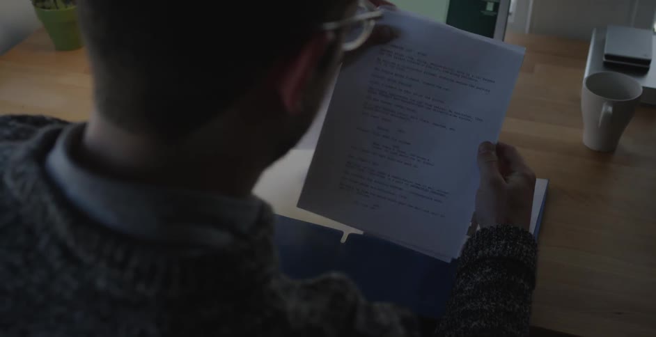 A man looking through papers at a desk