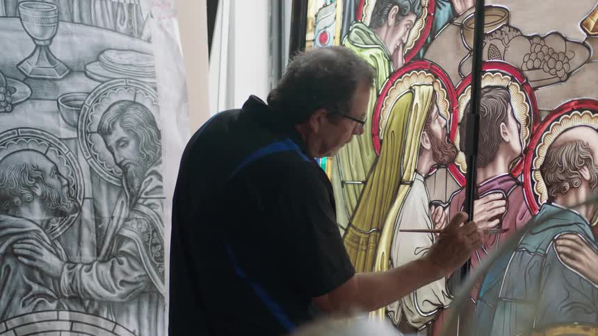 Man wearing black shirt painting on glass image