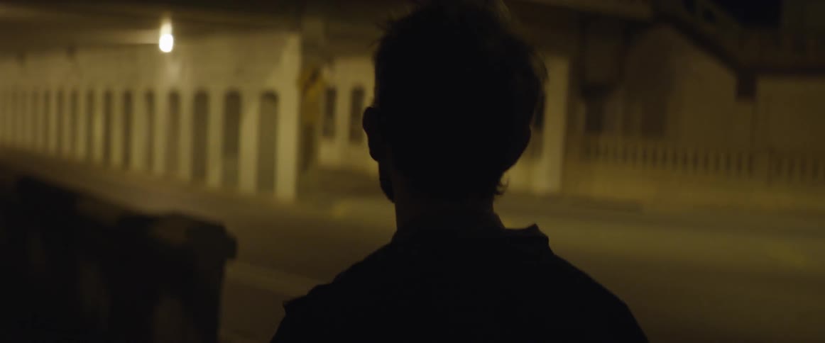 A man walking towards a tunnel with lights