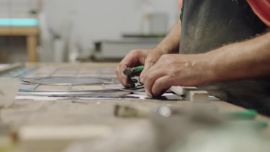 Artist in black apron working on project
