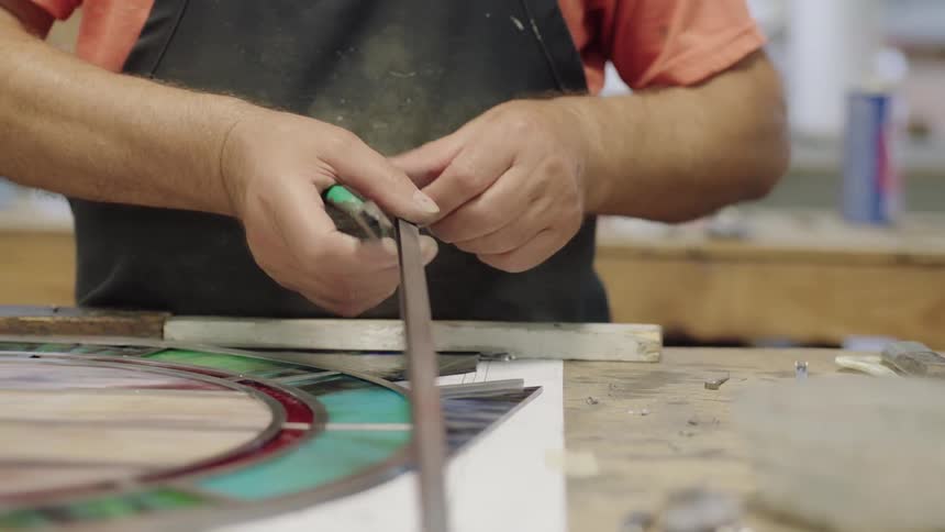 Artist using tools to cut metal piece