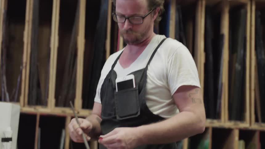 Artist in studio cutting glass