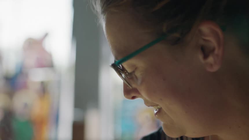 Female painter smiles between brush strokes