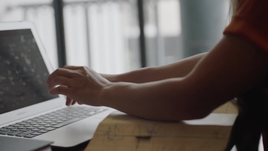 Moving book to table to write on laptop