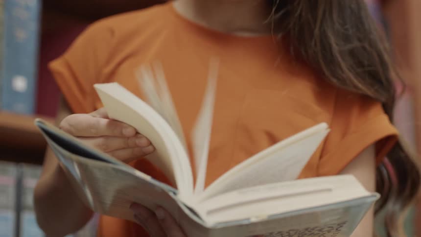 Student looking through book in library