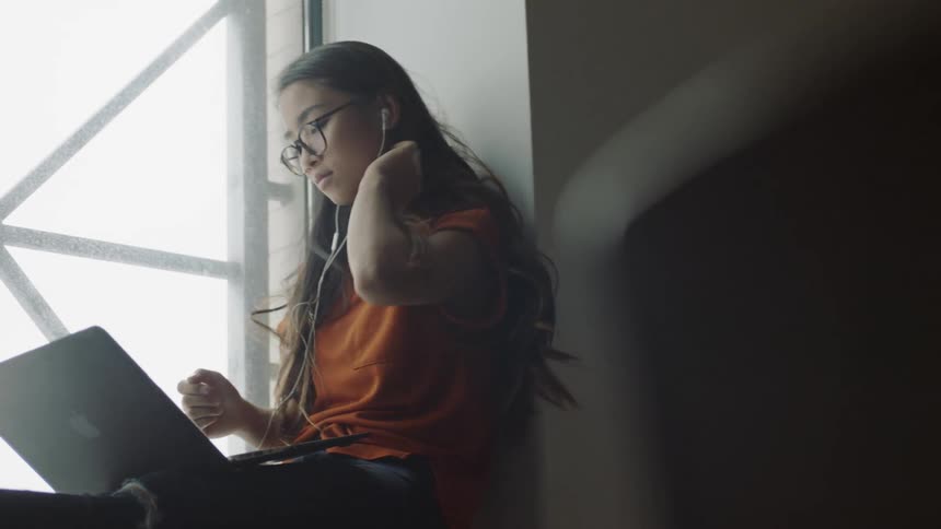 Student putting in head phones with computer
