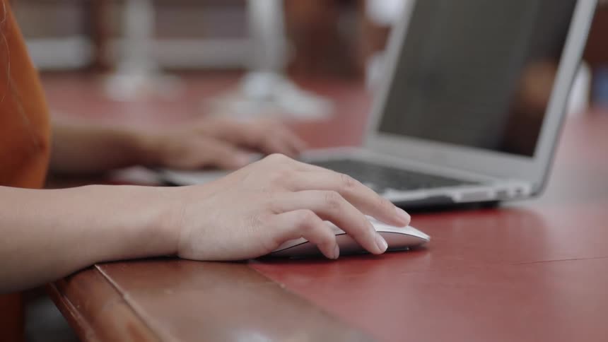 Student moving computer mouse looking at screen