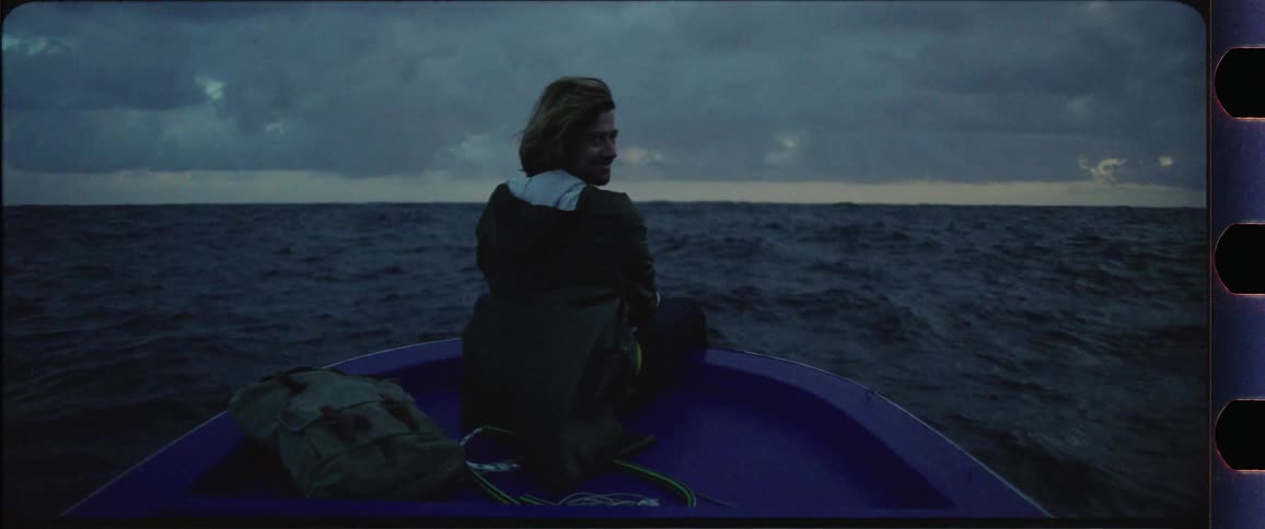 Man sitting at the front of a boat going up and down with the waves