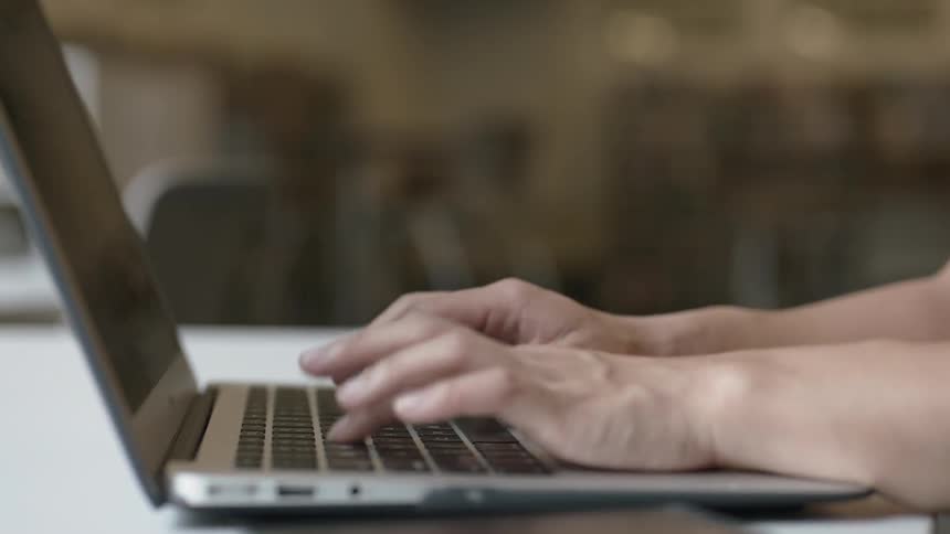 Typing on silver laptop