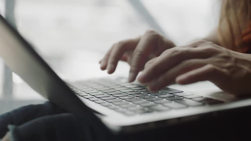 Fingers typing on laptop