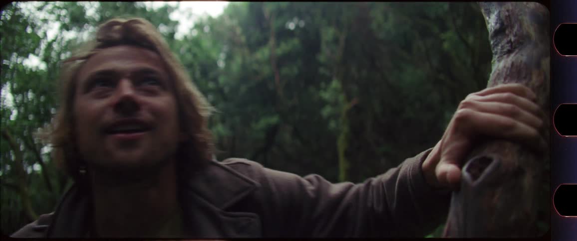 Man touching a tree while hiking through the forest