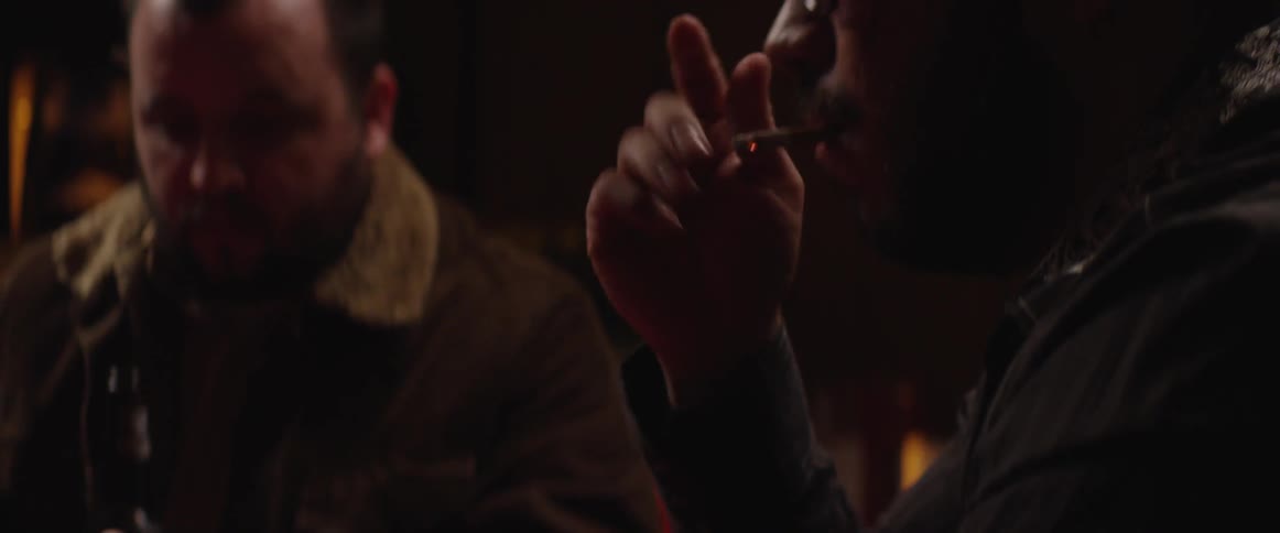 Man smoking and placing a bet while playing cards