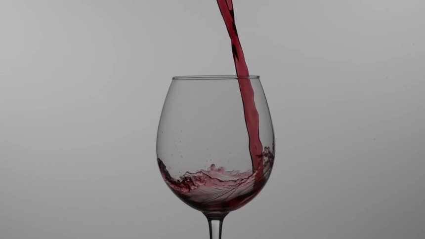 Red wine is poured into a glass