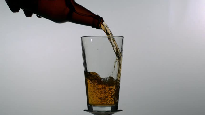 Beer is being poured into a pint glass
