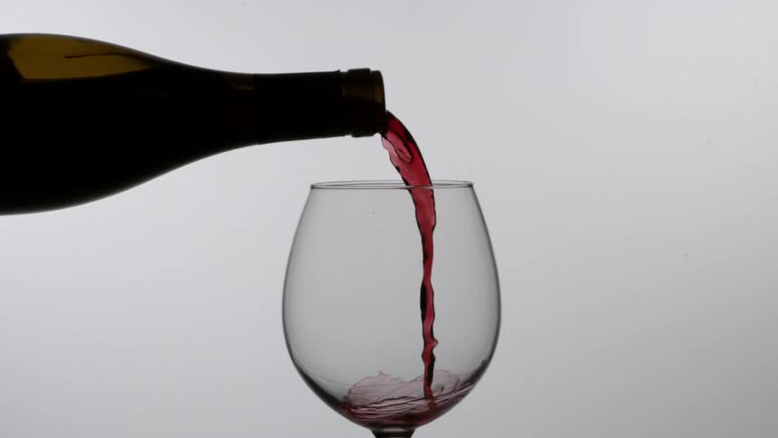 Red wine is poured into a glass