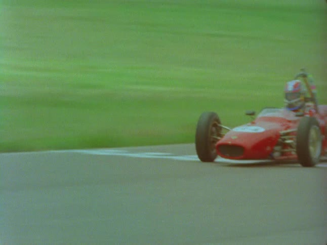 Two vintage race cars driving on a track