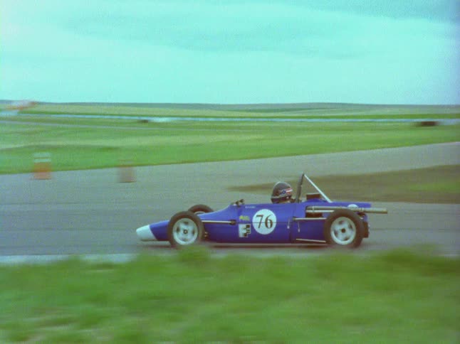 A race car driver speeds down a track