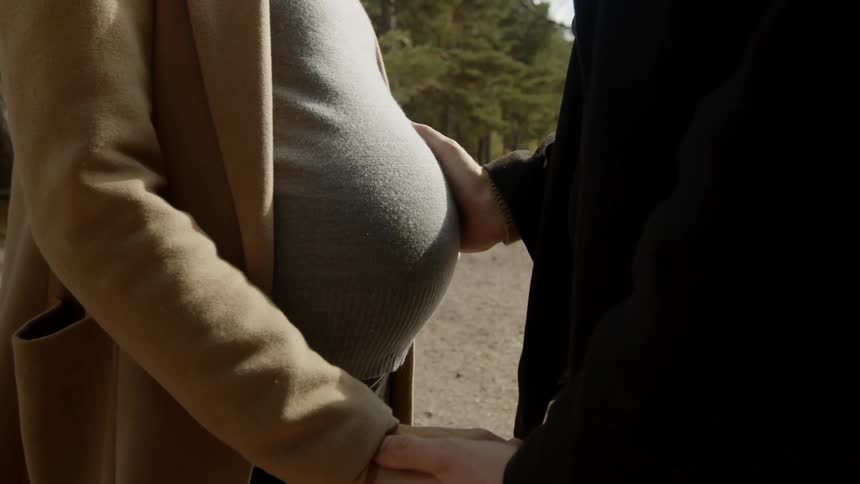 Expecting Couple Walking In The Forest
