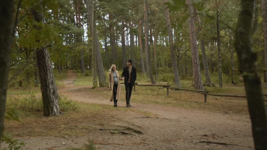 Expecting Couple Walking In The Forest