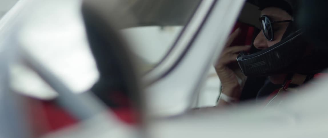 A driver puts on his seat belt in a vehicle