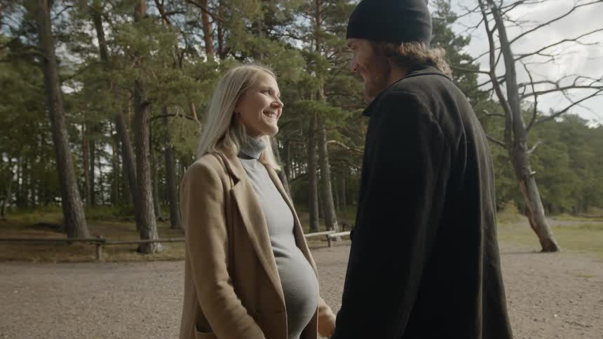 Expecting Couple Walking In The Forest
