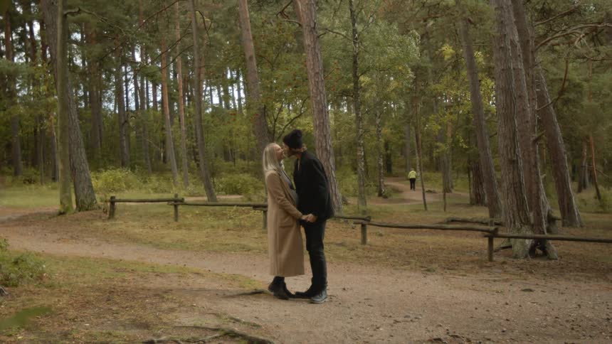 Expecting Couple Walking In The Forest