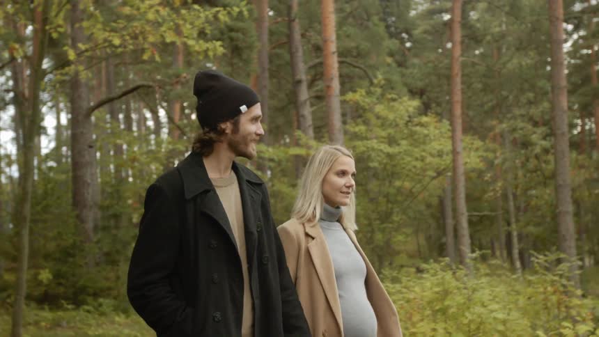 Expecting Couple Walking In The Forest
