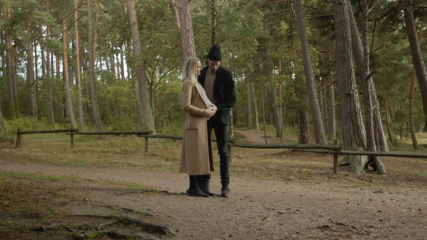 Expecting Couple Walking In The Forest