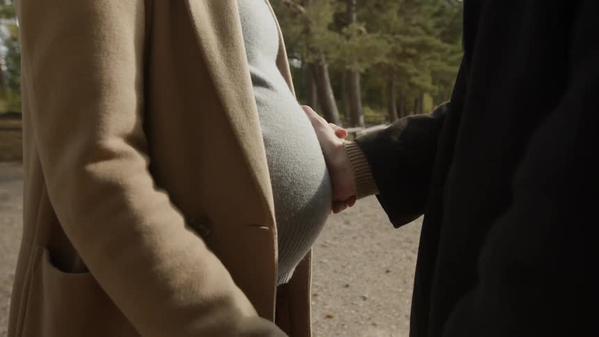 Expecting Couple Walking In The Forest