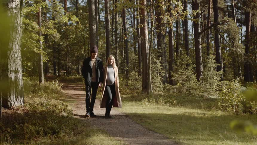 Expecting Couple Walking In The Forest