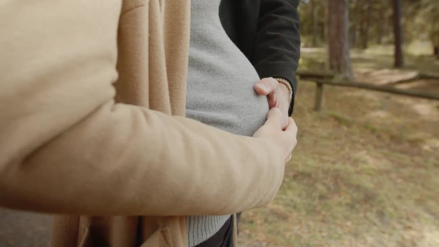 Expecting Couple Walking In The Forest