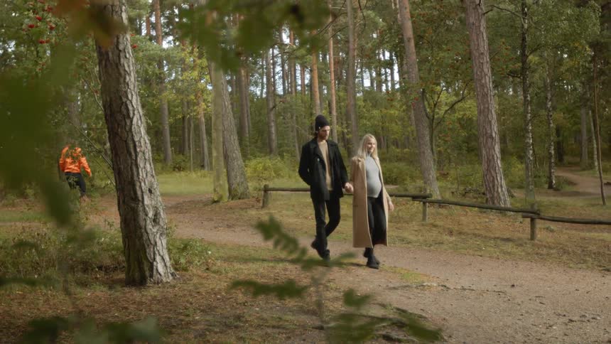 Expecting Couple Walking In The Forest