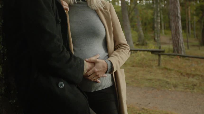 Expecting Couple Walking In The Forest