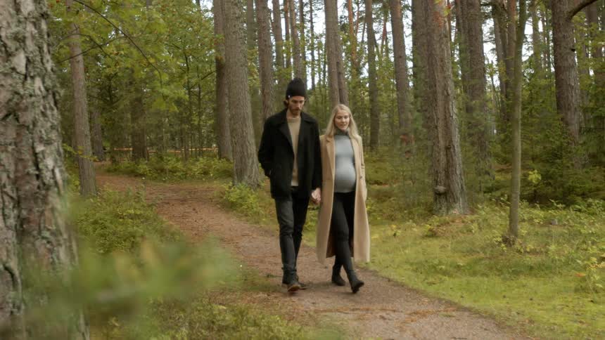 Expecting Couple Walking In The Forest