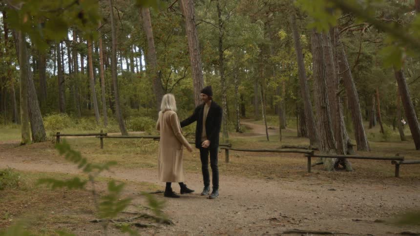 Expecting Couple Walking In The Forest