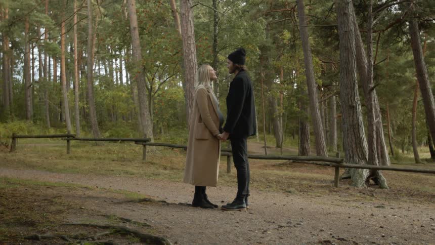 Expecting Couple Walking In The Forest
