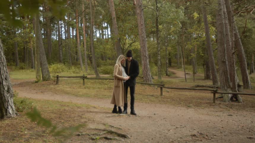 Expecting Couple Walking In The Forest