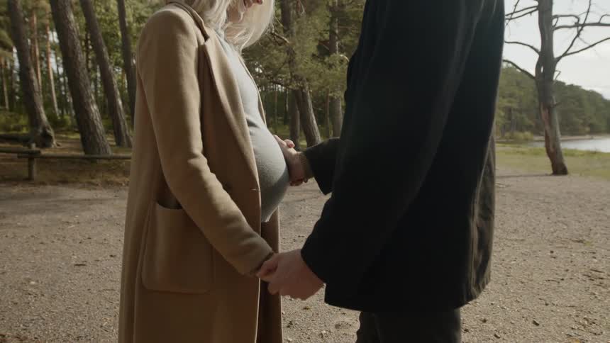 Expecting Couple Walking In The Forest