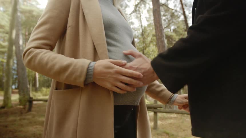 Expecting Couple Walking In The Forest