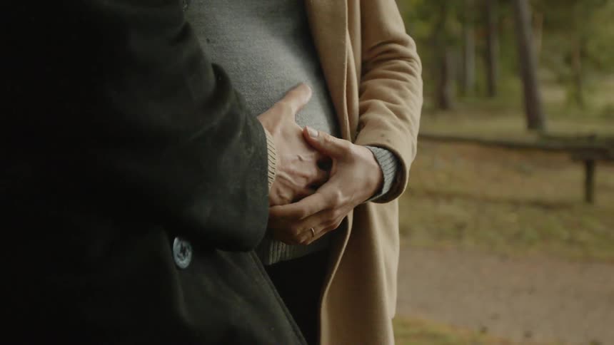 Expecting Couple Walking In The Forest