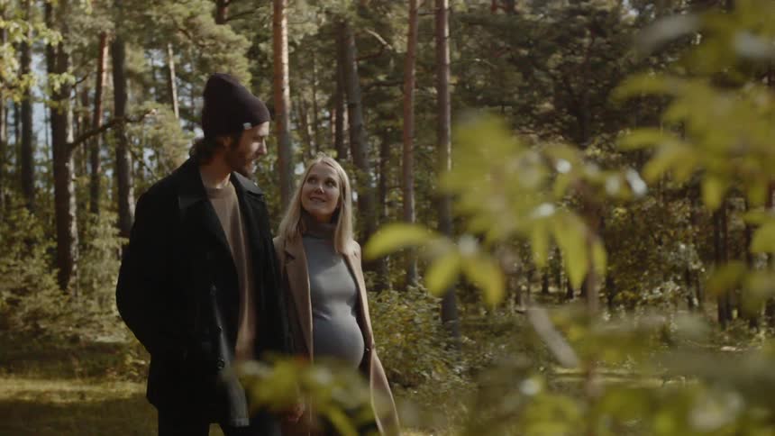 Expecting Couple Walking In The Forest