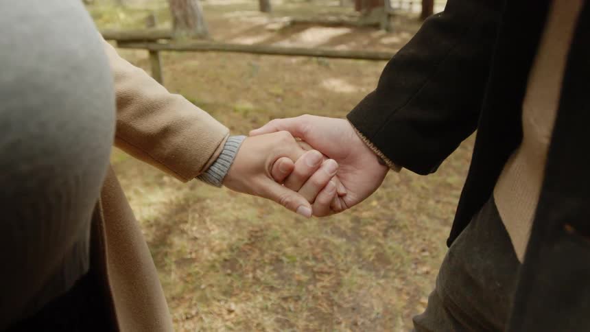 Expecting Couple Walking In The Forest