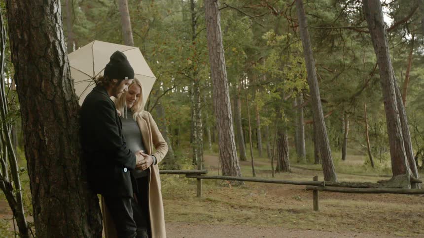 Expecting Couple Walking In The Forest
