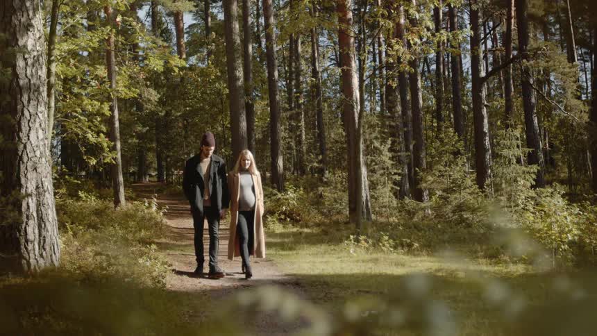 Expecting Couple Walking In The Forest