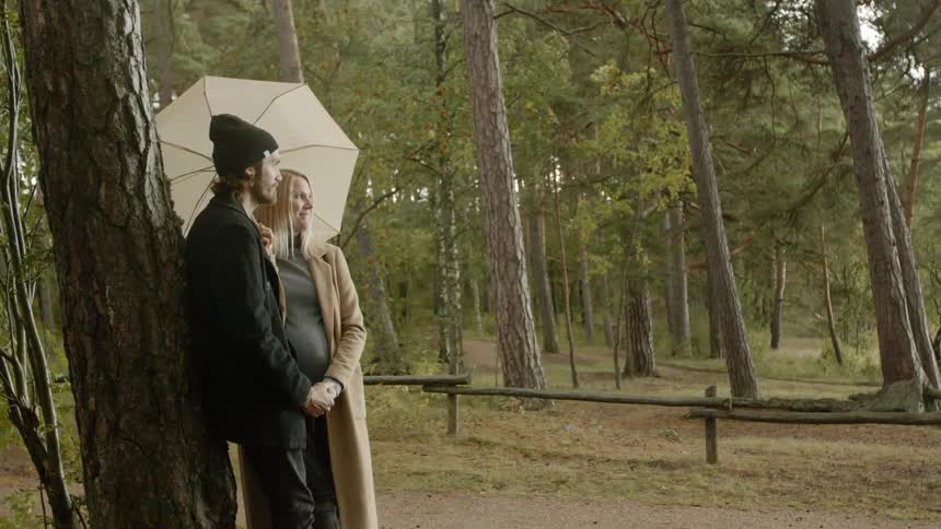 Expecting Couple Walking In The Forest