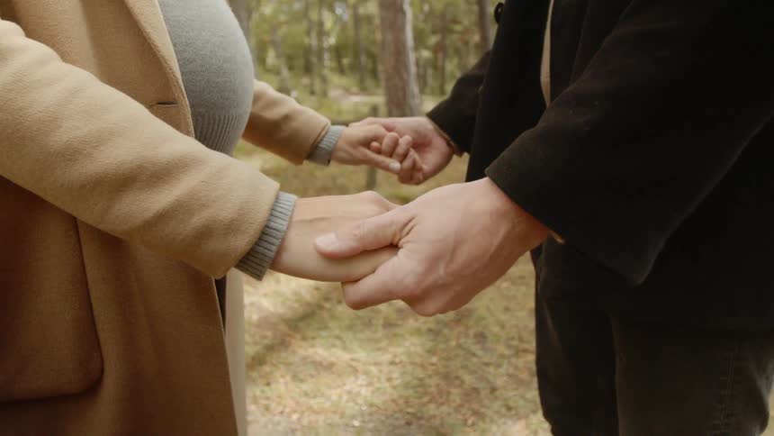 Expecting Couple Walking In The Forest