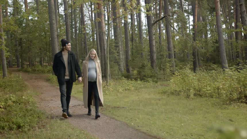 Expecting Couple Walking In The Forest