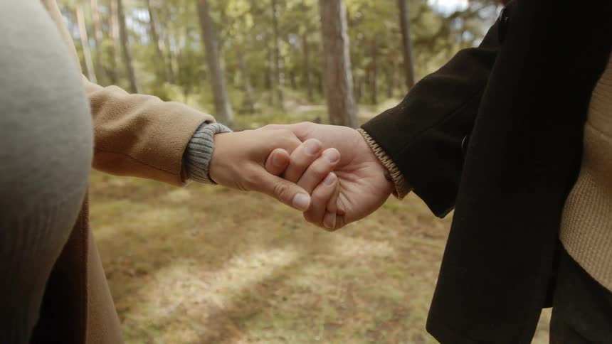 Expecting Couple Walking In The Forest